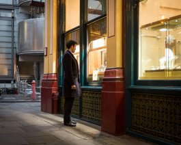 business man in central London looking into shop window 