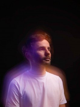 studio portrait of musician, dj, long exposure with violet and orange light 
