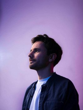 studio portrait of musician, dj, violet background 