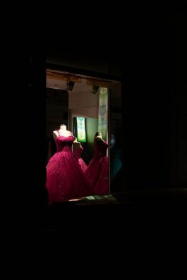 photography of shop window with pink dress at night, urban landscape