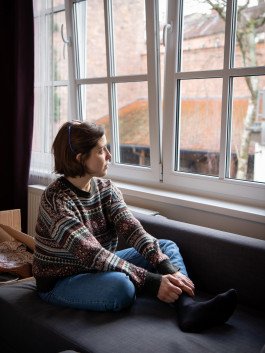 location portrait of young woman sitting near window with natural light reportage documentary 