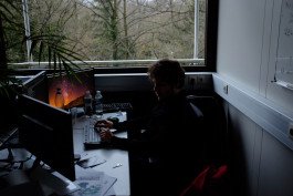 person working at computer forest putside the window 